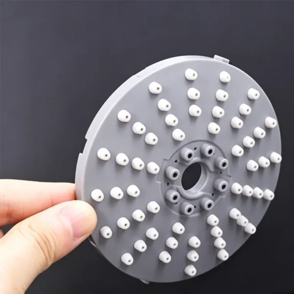 Gray plastic shower nozzle plate with multiple white spray nozzles