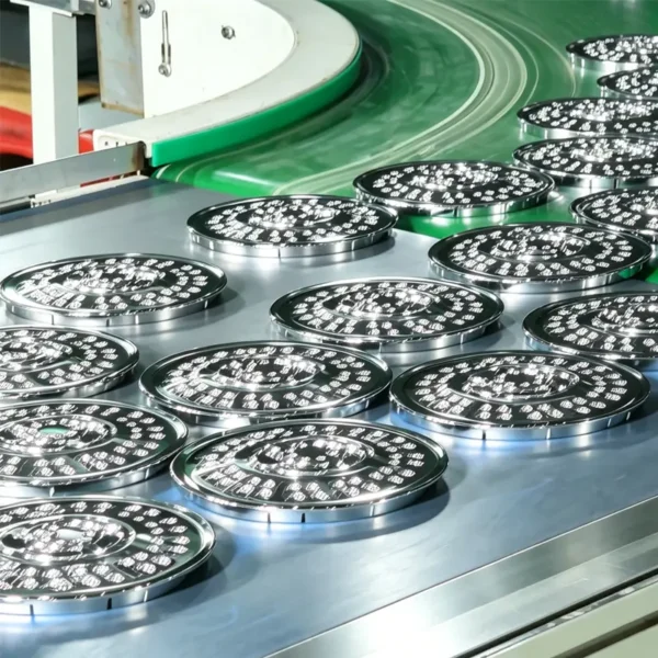 Chrome finished shower head panels moving along factory production conveyor belt