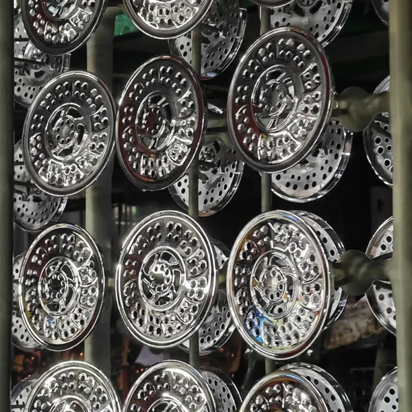Chrome shower head panels hanging on racks during electroplating manufacturing process